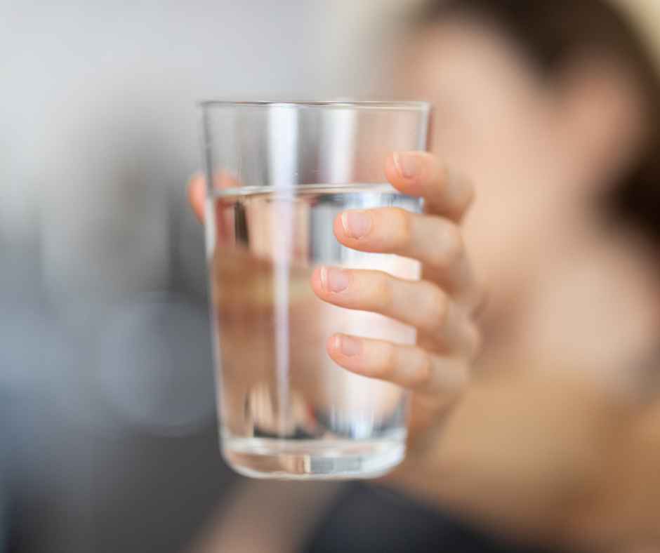 Holding a clear glass of water